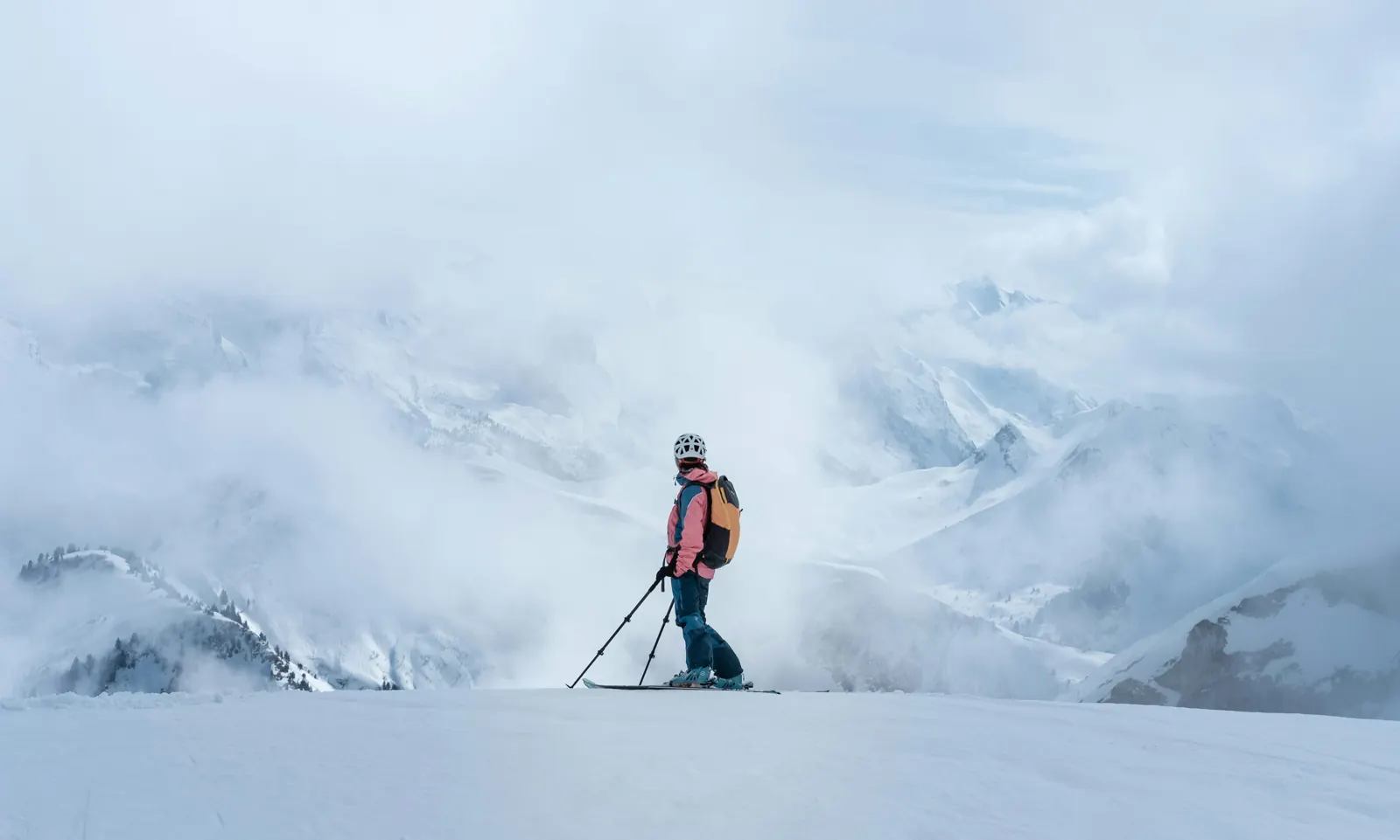 Skier overlooking misty peaks